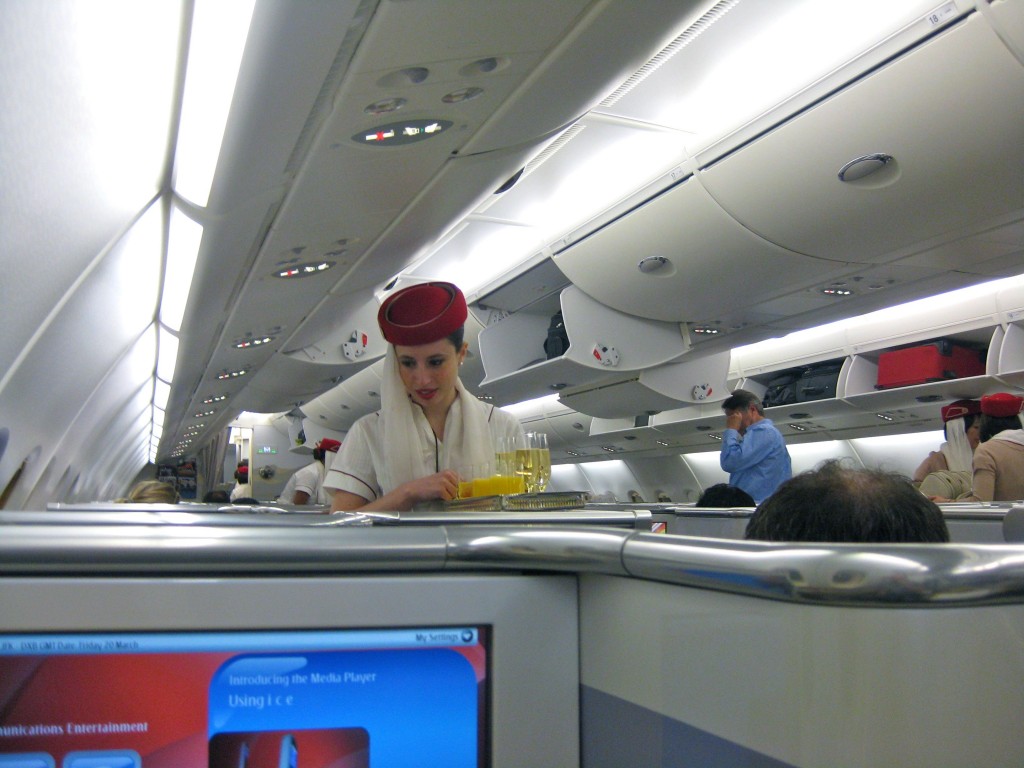 a woman in a red hat and white coat on an airplane