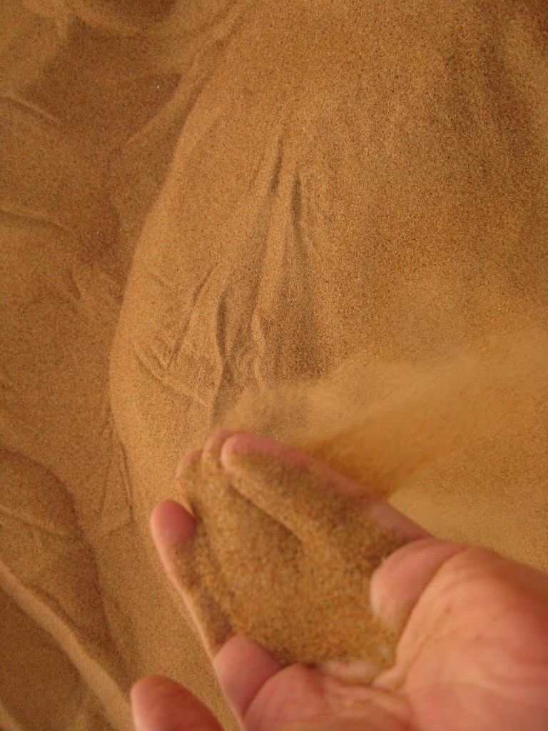 a person pouring sand into a pile