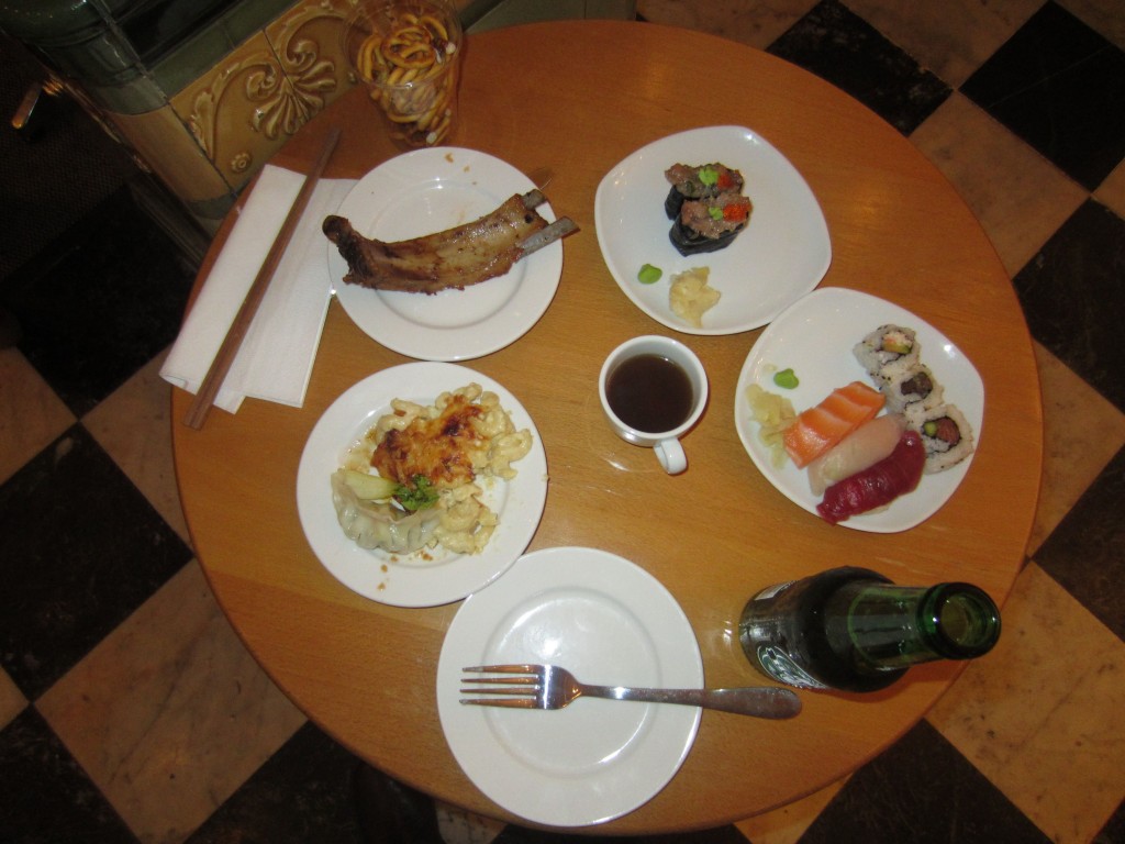 a table with plates of food and a bottle of beer