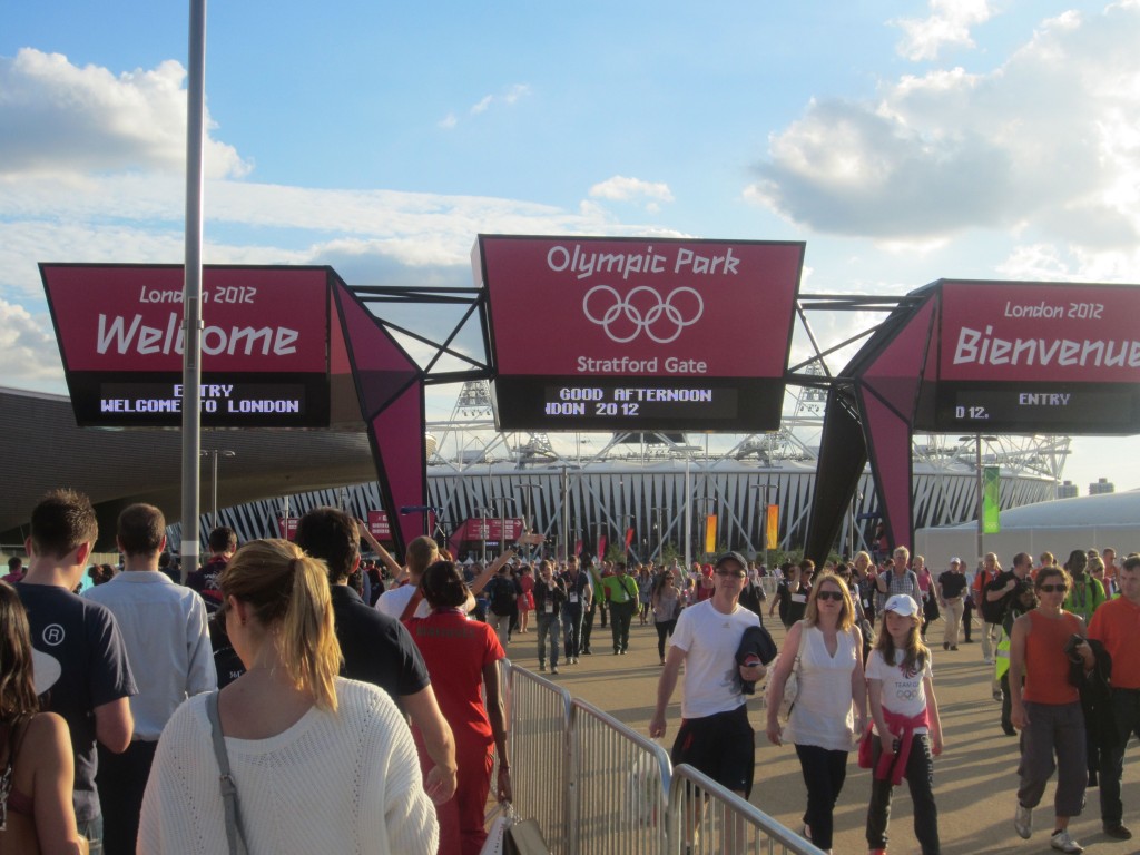 a crowd of people walking in front of a large sign