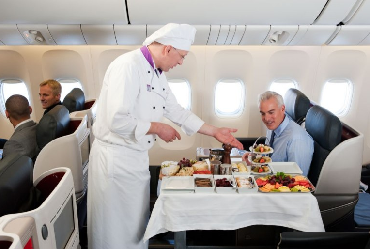 a chef serving a man in an airplane