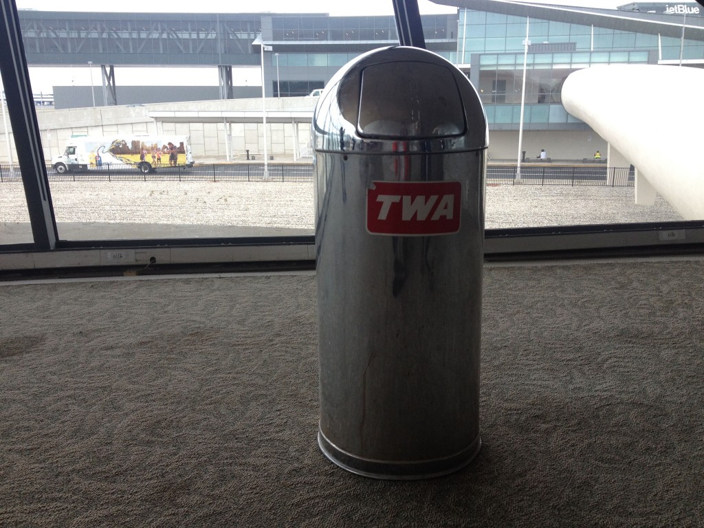 a silver trash can with a red sticker on it