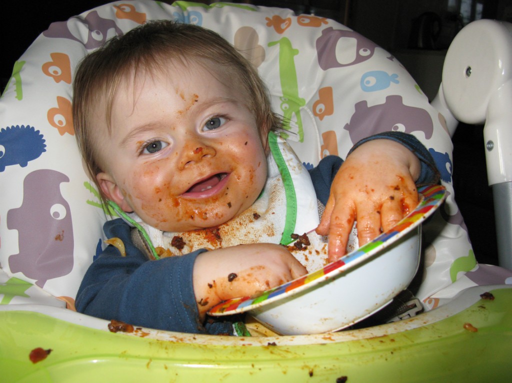 a baby with nice face and food in a bowl