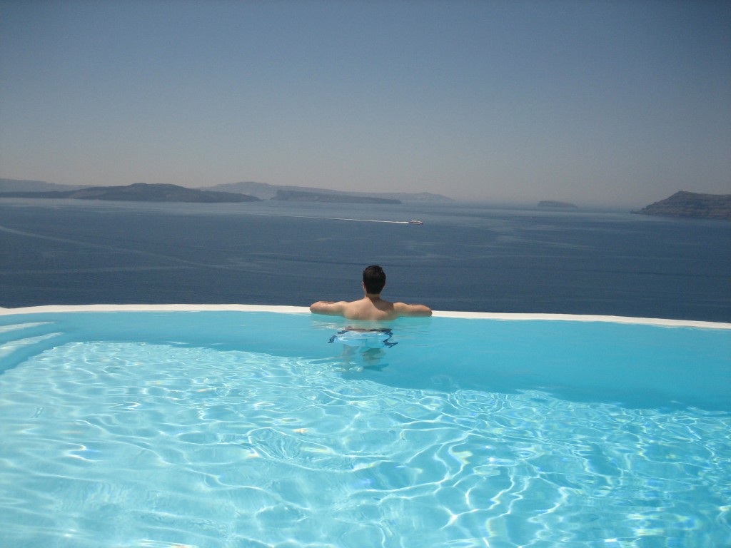 a man in a pool overlooking the ocean