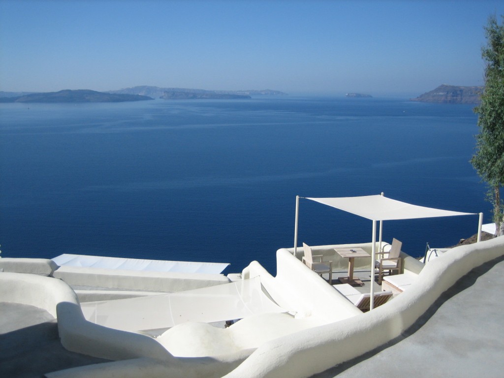 a white building with a white roof and a white canopy over the water