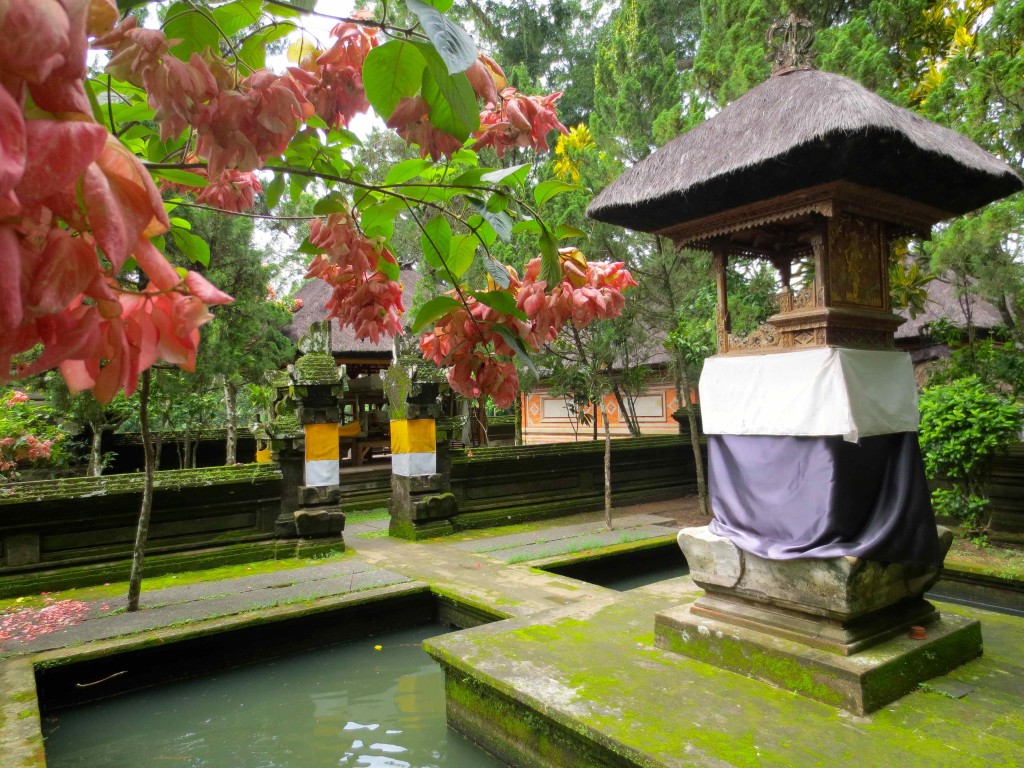 a small shrine with a roof and a small pond with flowers