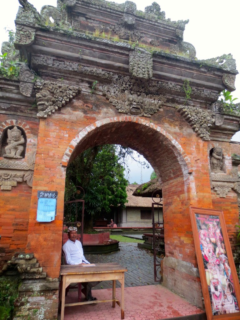 a man sitting in a chair under a stone archway