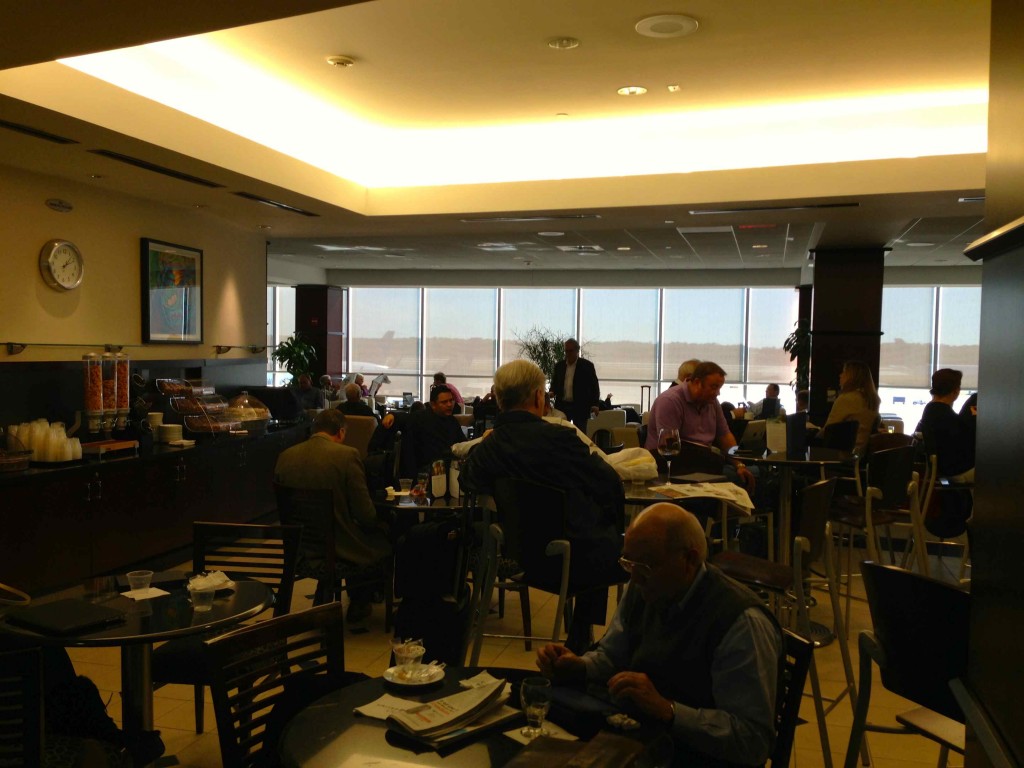 a group of people sitting at tables in a room with large windows