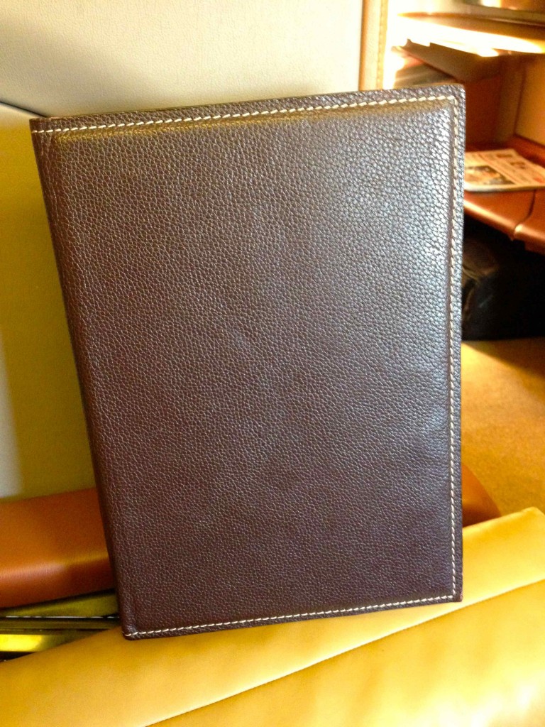 a brown leather book on a yellow envelope