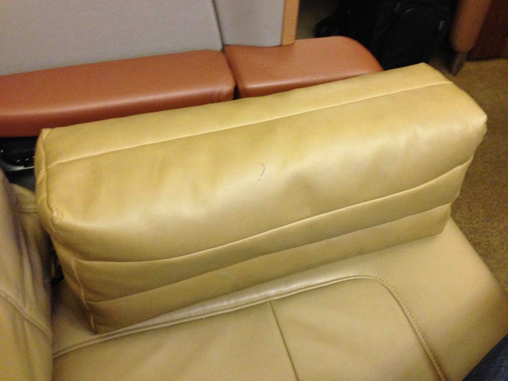 a tan leather pillow on a couch