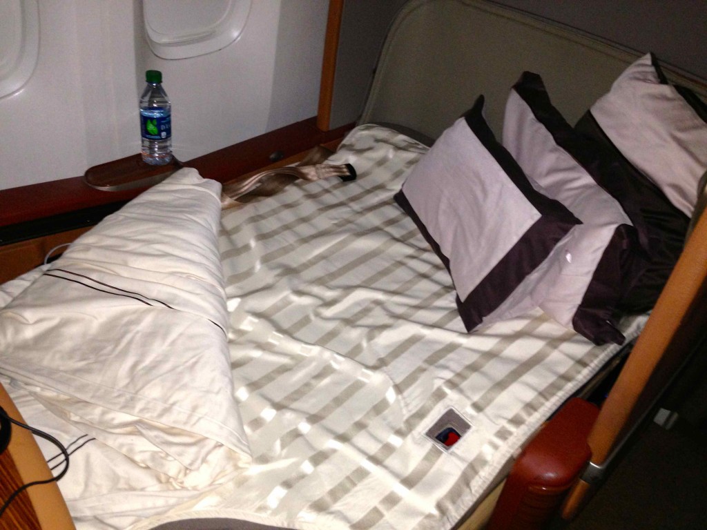 a bed with pillows and a bottle of water on the side