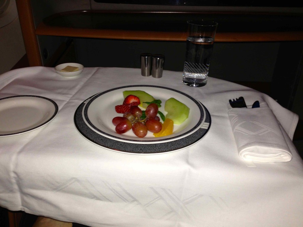 a plate of fruit and water on a table