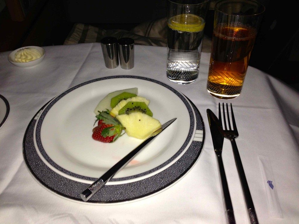 a plate with fruit on it and a fork and knife on a table
