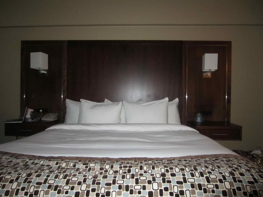 a bed with white pillows and a brown headboard