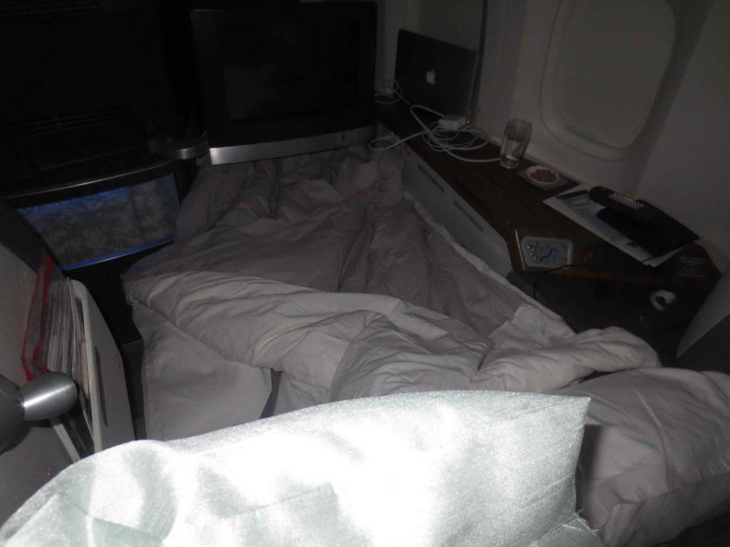 a bed with a blanket and a tv on it