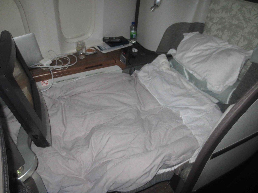 a bed with a white sheet and a white pillow on the side of the bed