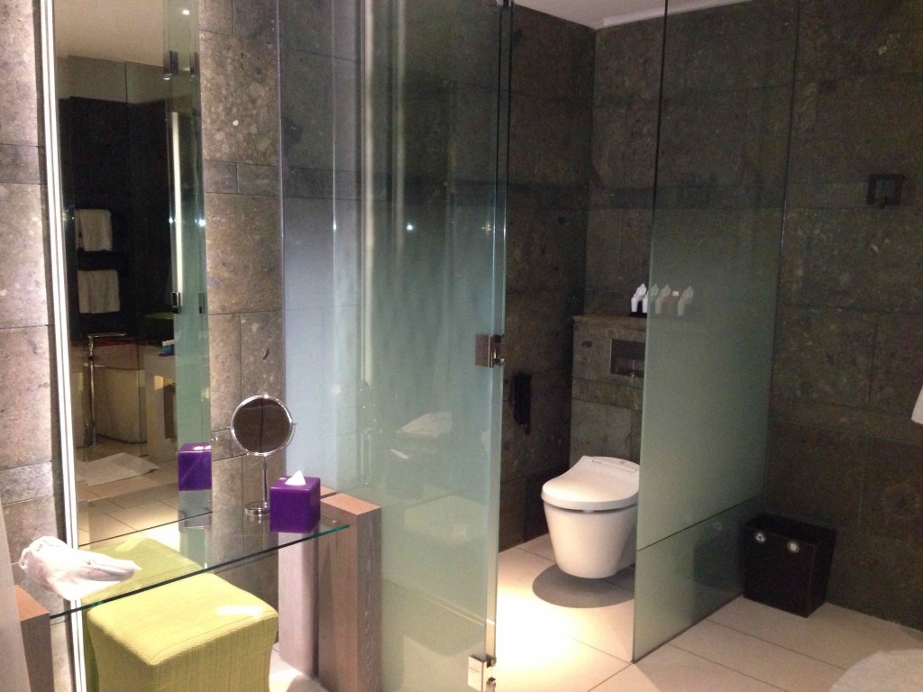 a bathroom with glass walls and a toilet