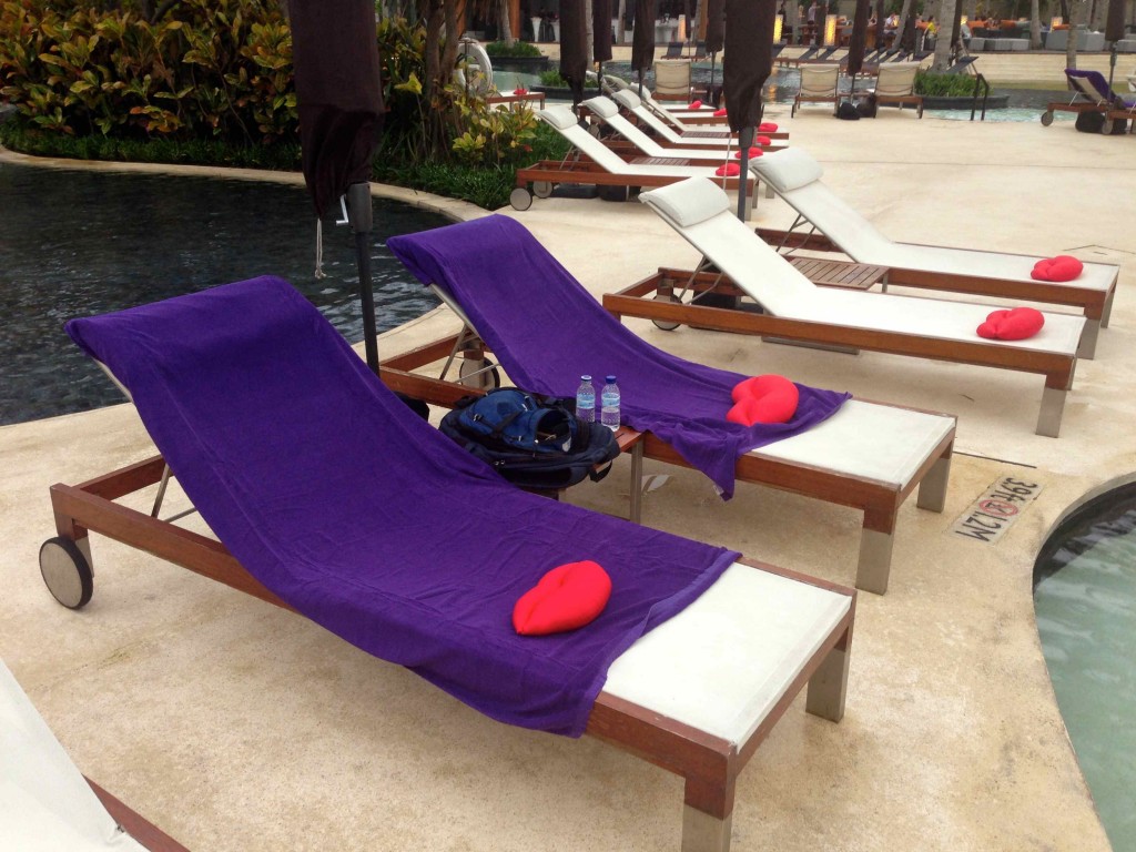 a group of lounge chairs by a pool