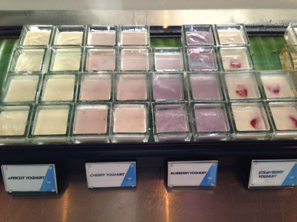 a group of different yogurt in square glass containers
