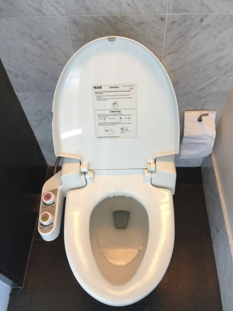 a toilet with buttons and a seat