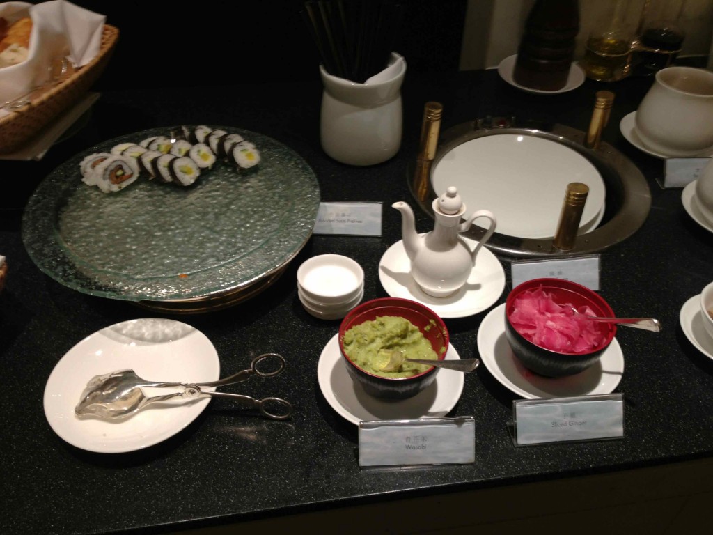 a table with plates and bowls of sushi