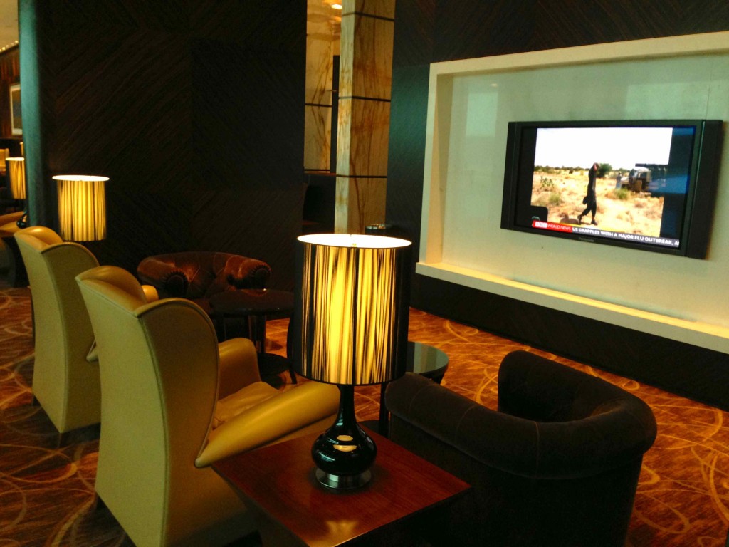 a room with a television screen and a lamp