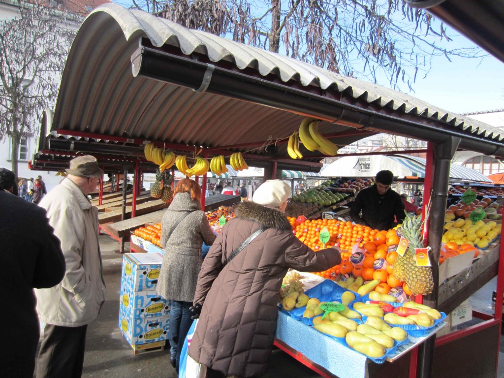 people standing in front of a fruit stand