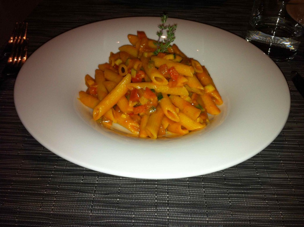 a plate of pasta with a sprig of thyme
