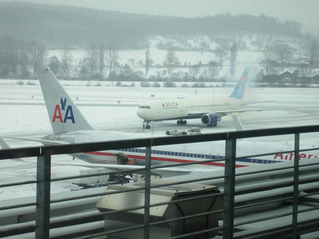 two airplanes on a runway in the snow