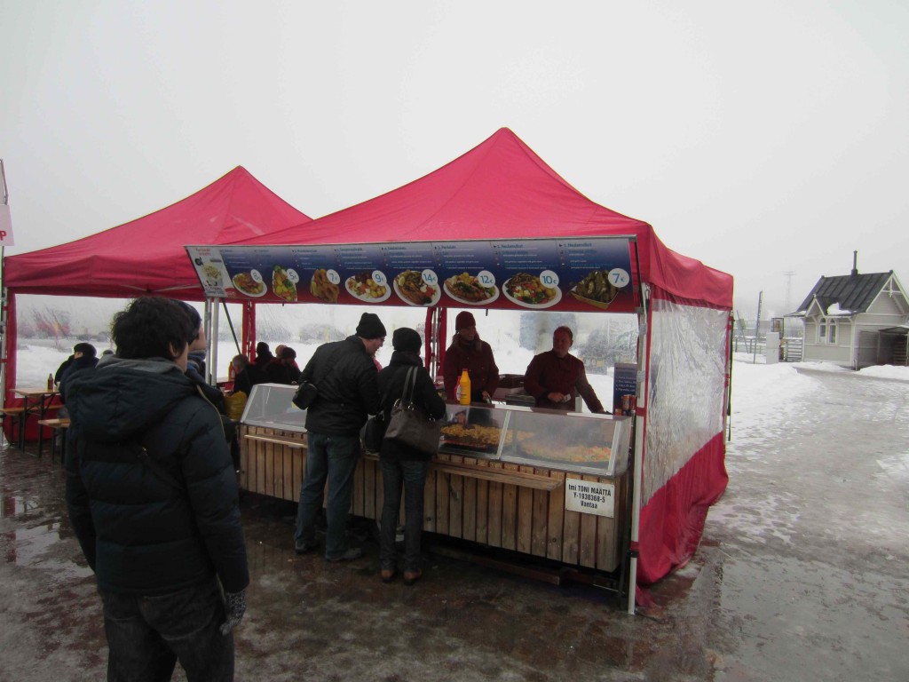 a group of people standing in front of a food stand