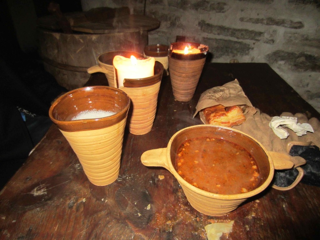 a group of cups with food and a candle on a table