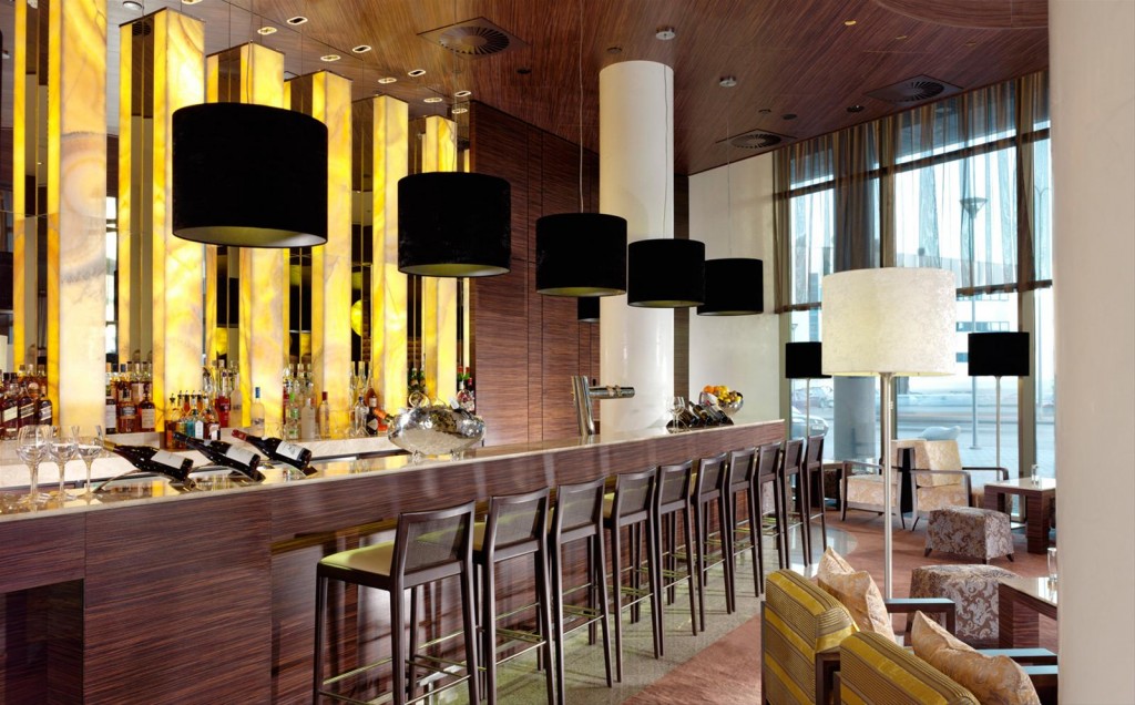 a bar with black lamps and chairs