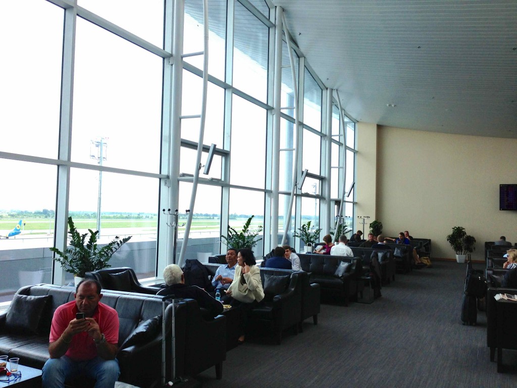 people sitting in a room with large windows