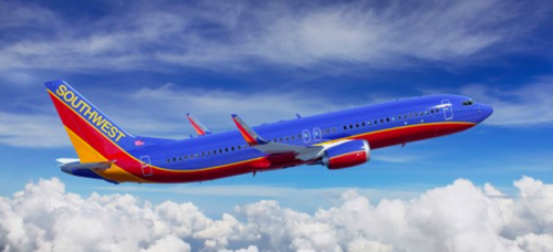 a blue and red airplane flying in the sky