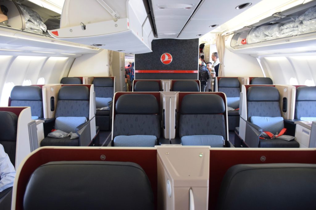 the inside of an airplane with seats and people
