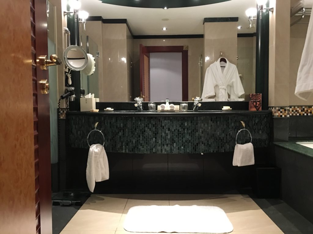 a bathroom with a mirror and a white robe
