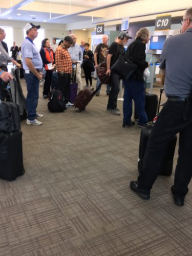 a group of people standing in a line with luggage