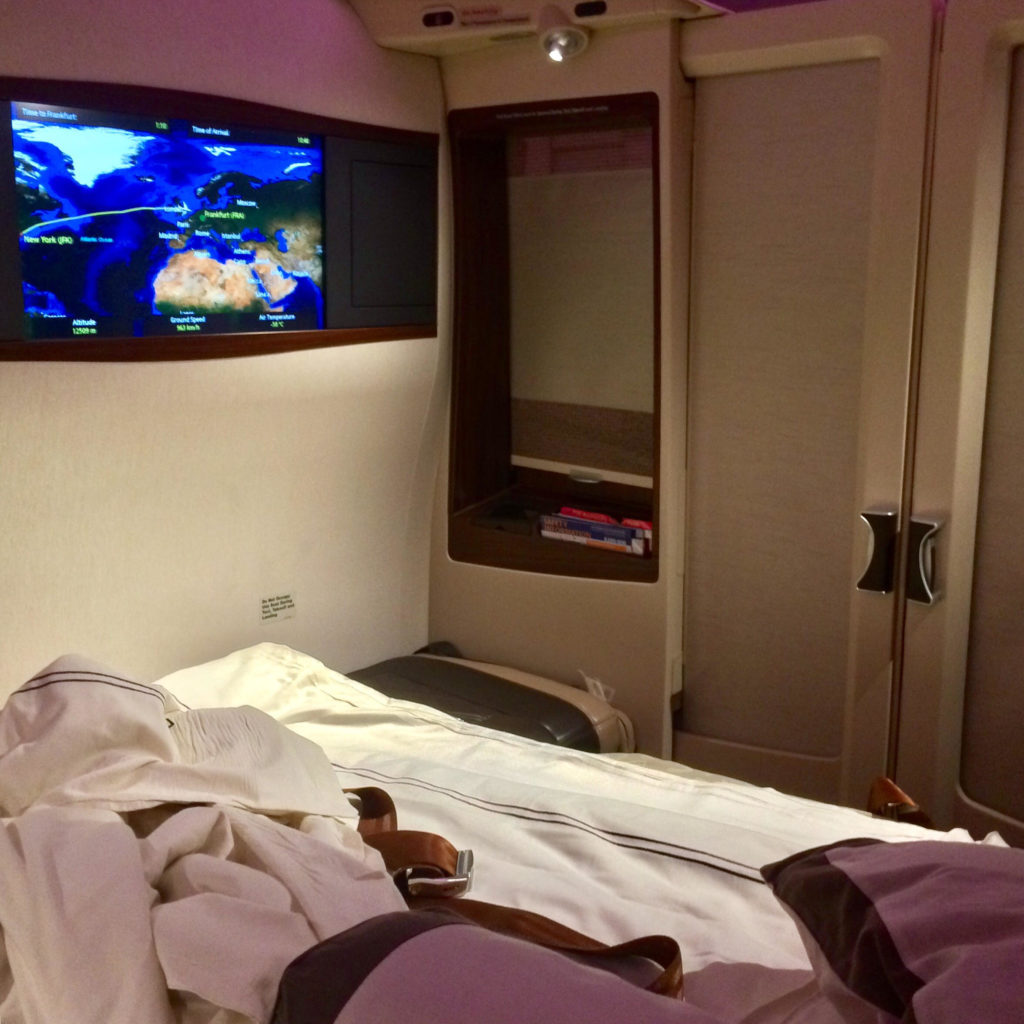 a bed with a television on the wall