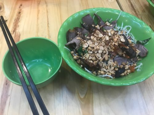 a bowl of food with chopsticks