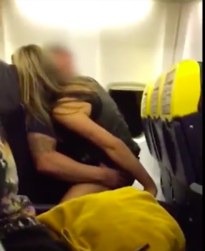 a man and woman hugging on an airplane