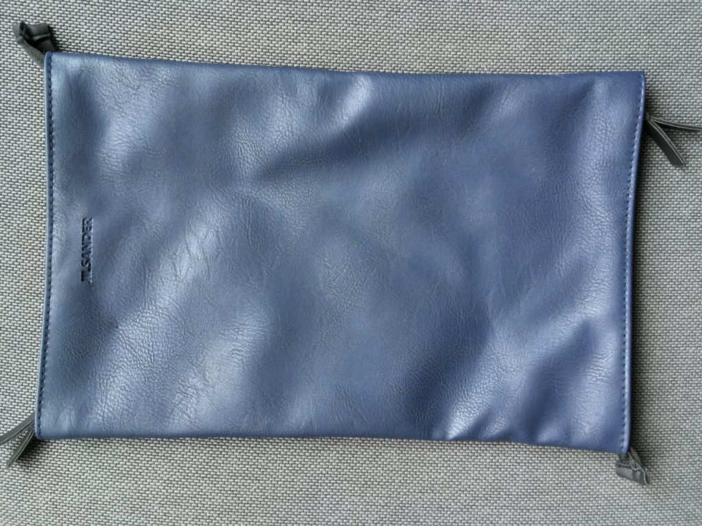 a blue leather pouch on a gray surface