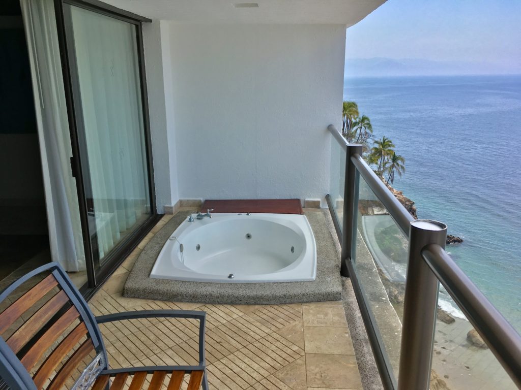 a jacuzzi on a balcony overlooking the ocean