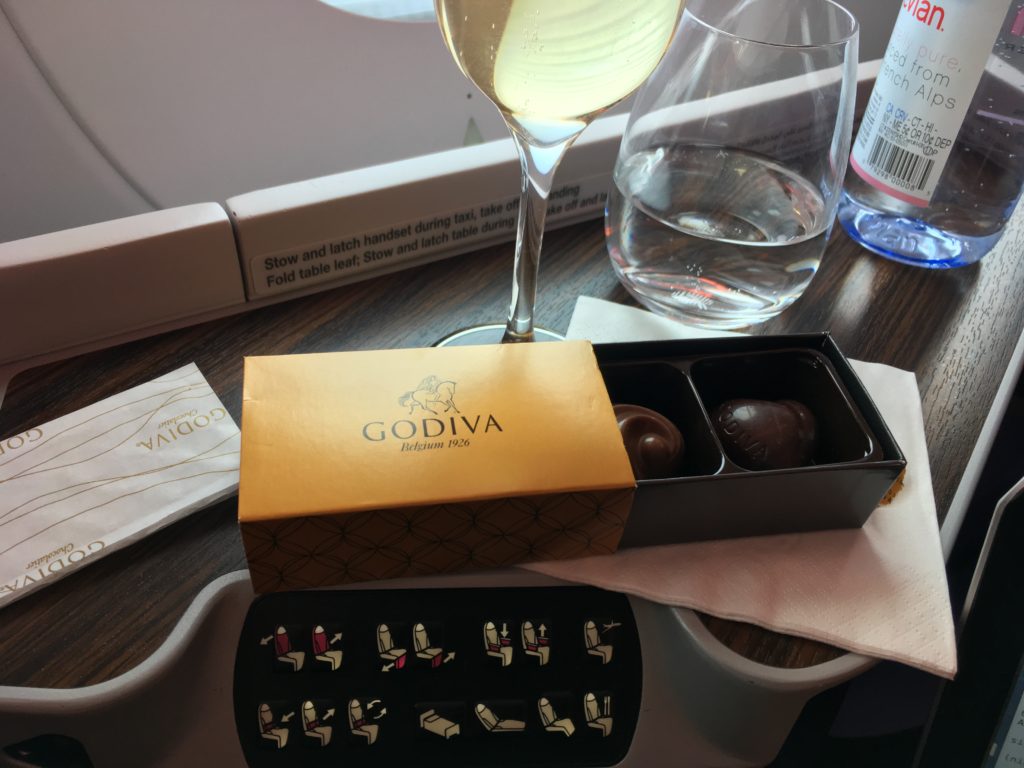a box of chocolates and a glass of wine