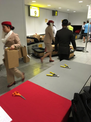 people in a room with a table with scissors and a box