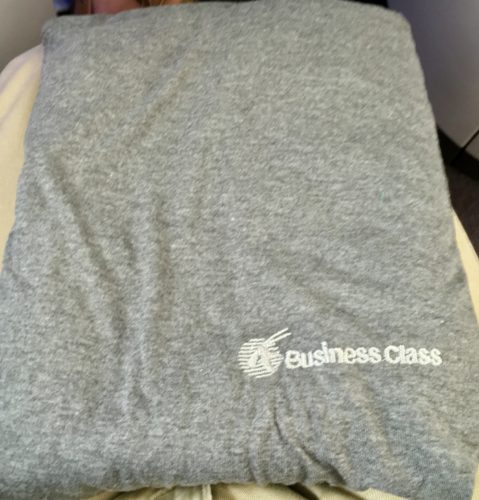 a grey folded blanket on a bed