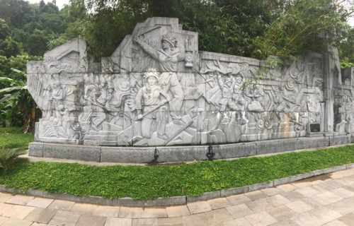 a stone wall with a sculpture of people