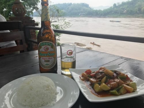 a plate of food and a beer on a table