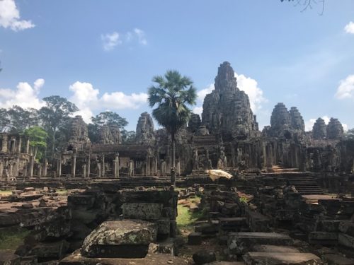 a ruins of a temple with Angkor Wat in the background