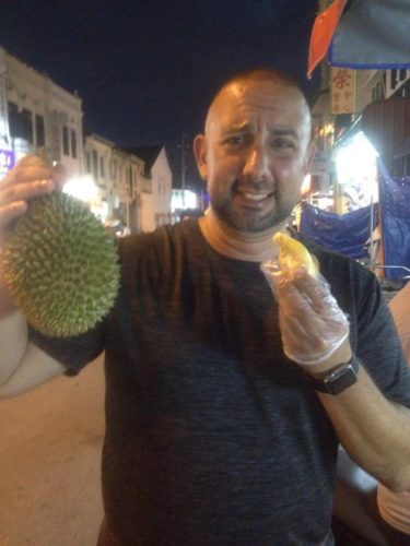 a man holding a durian