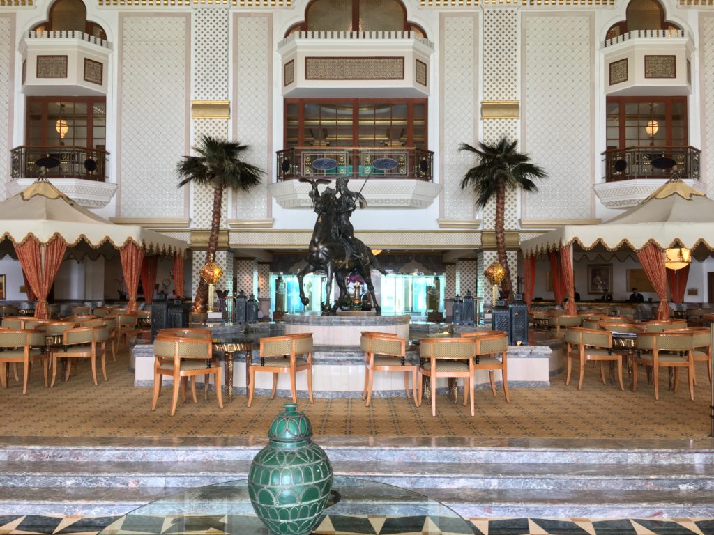 a room with a statue of a man on a horse and palm trees